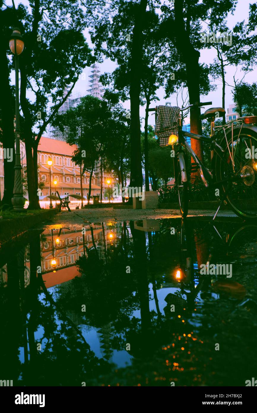 Réflexion miroir incroyable par l'étang après la pluie, arrêt en vélo dans le parc avec le fond rouge de mur de la cathédrale notre dame et de réfléchir sur l'eau au crépuscule Banque D'Images