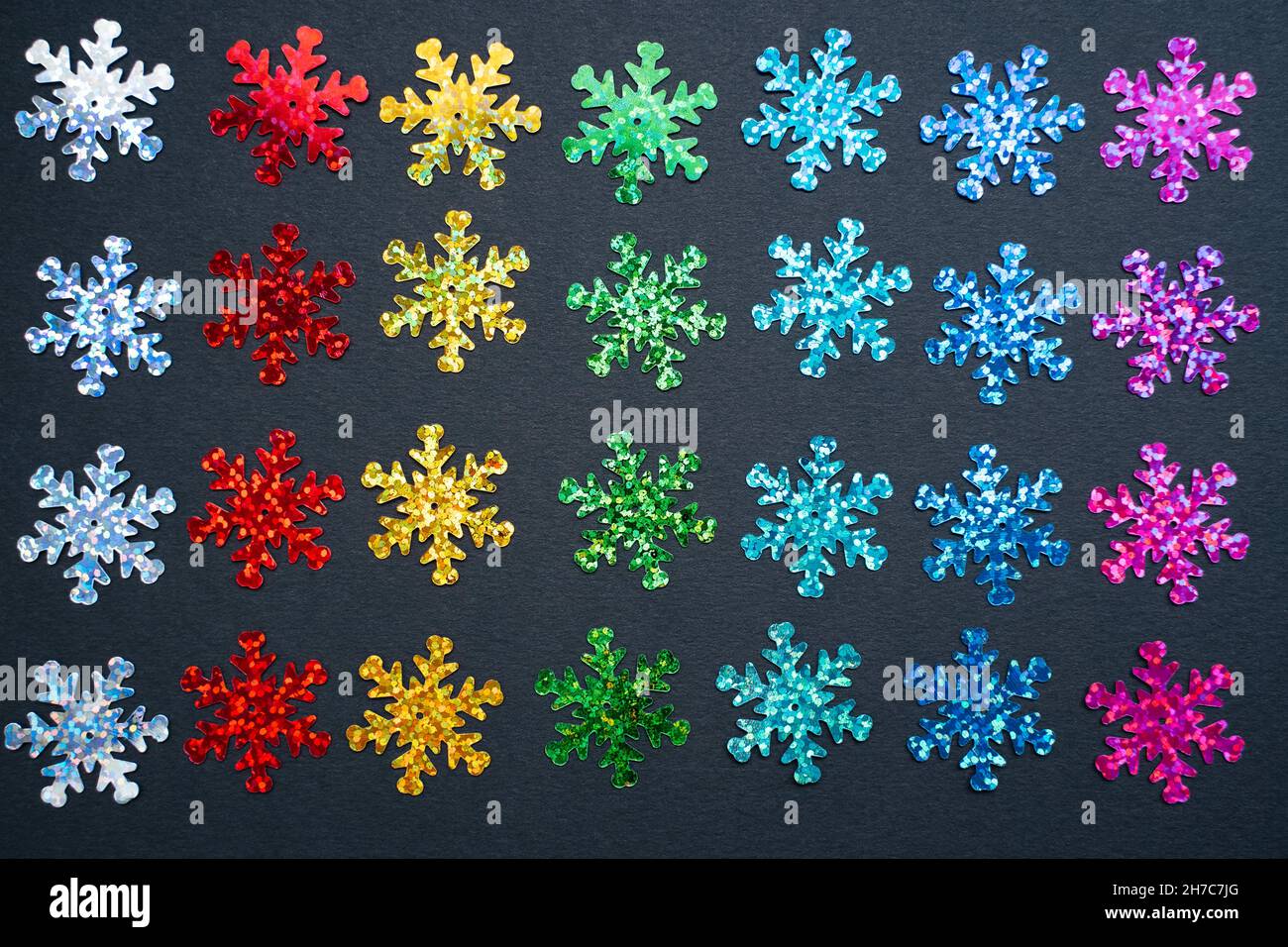 flocons de neige scintillants de couleur arc-en-ciel sur fond de papier noir.Bannière marketing LGBTQ inclus pour les fêtes d'hiver Banque D'Images