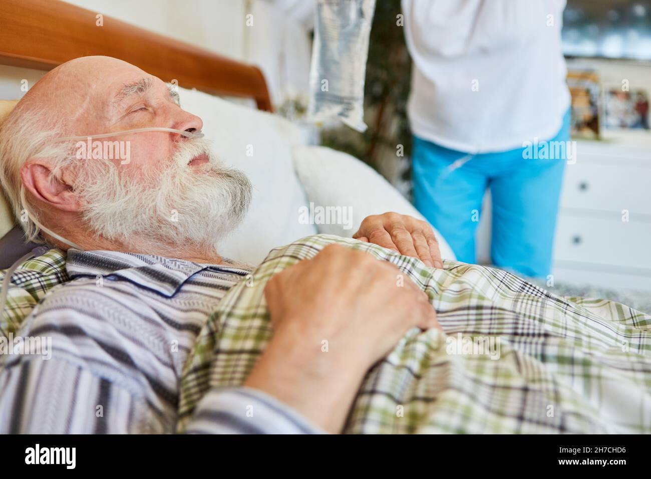 Malade senior avec canule d'oxygène dans le lit à l'hôpital ou dans les soins à domicile Banque D'Images