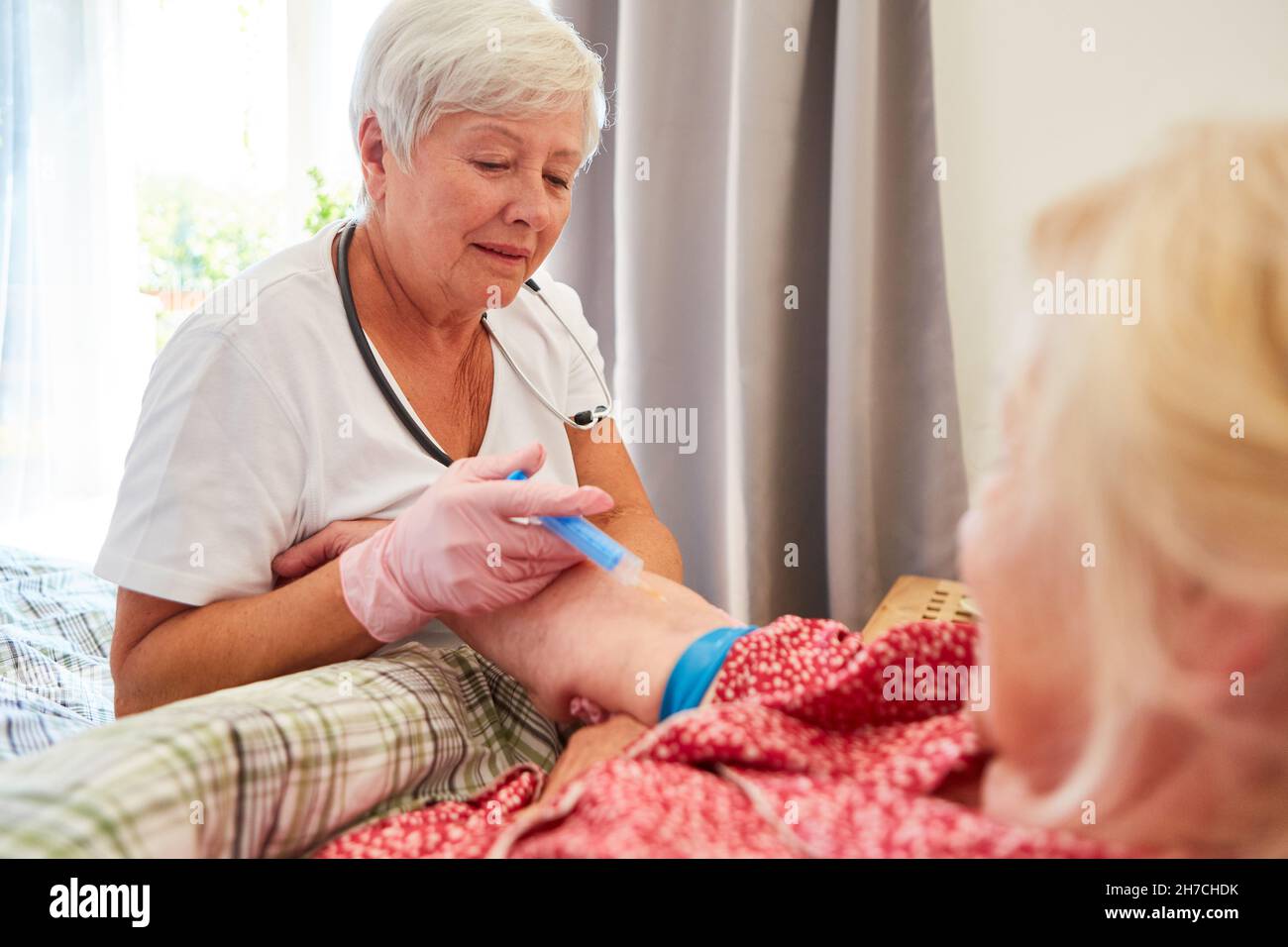 Le médecin ou l'infirmière injecte des analgésiques ou des vitamines dans un patient âgé Banque D'Images