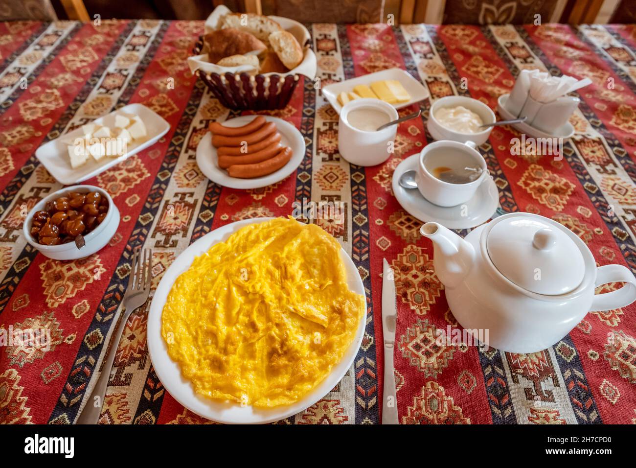 Petit déjeuner traditionnel avec omelette et saucisse sur une nappe Banque D'Images
