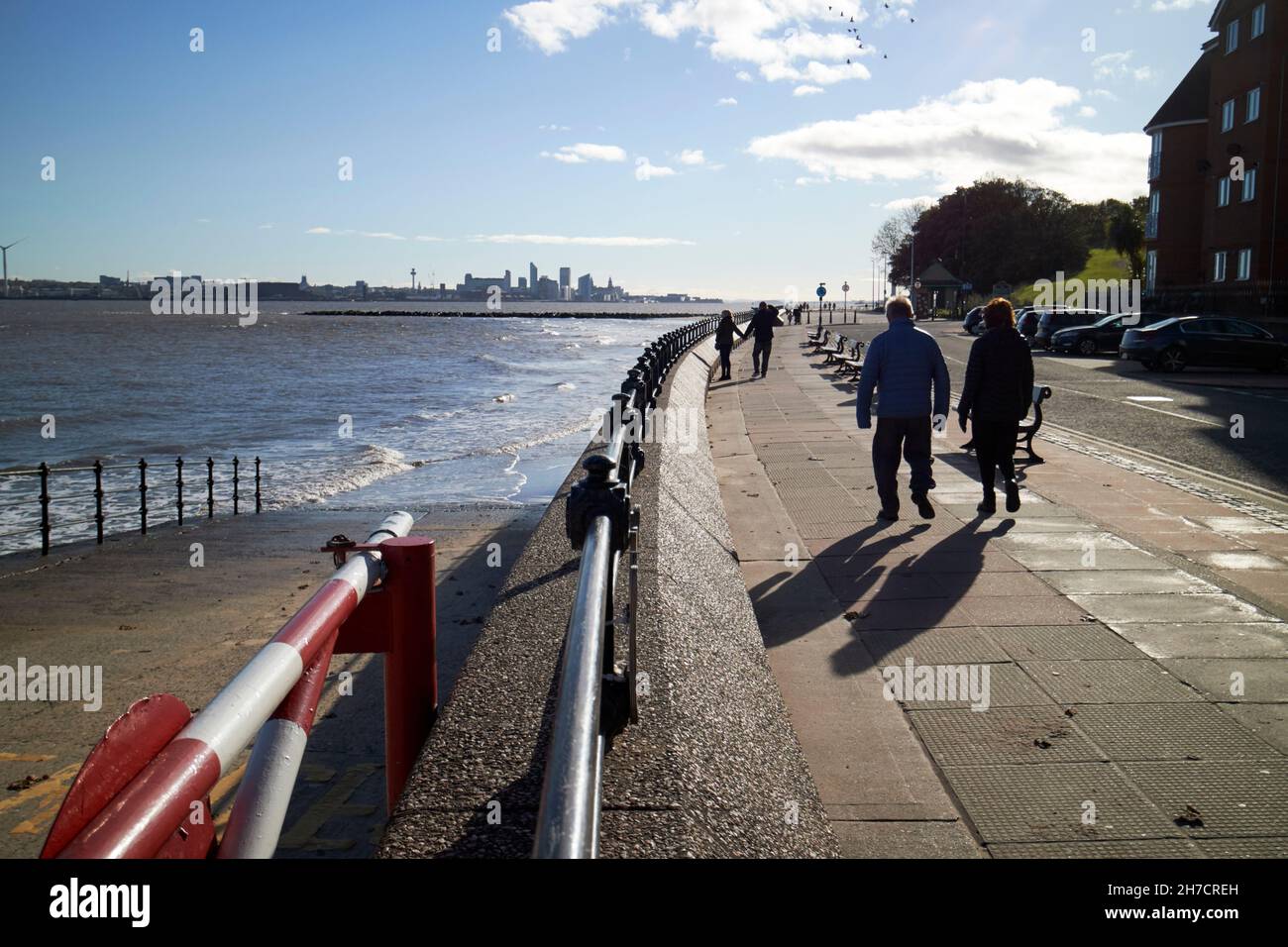 Couples marchant le long de la promenade de la tour et vue sur la rivière mersey et le centre-ville de liverpool au loin New Brighton le Wirral merseyside royaume-uni Banque D'Images