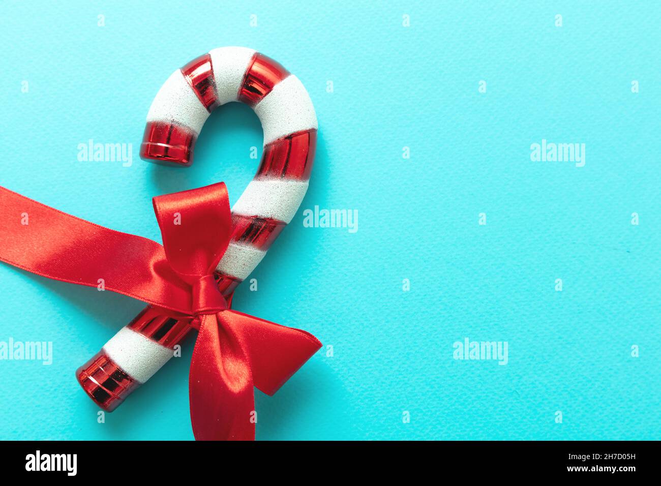 Canne à sucre avec ruban rouge noeud isolé sur fond bleu.Dessert blanc  rouge à la menthe de Noël.Modèle de carte de vœux Merry Xmas, espace de  copie Photo Stock - Alamy