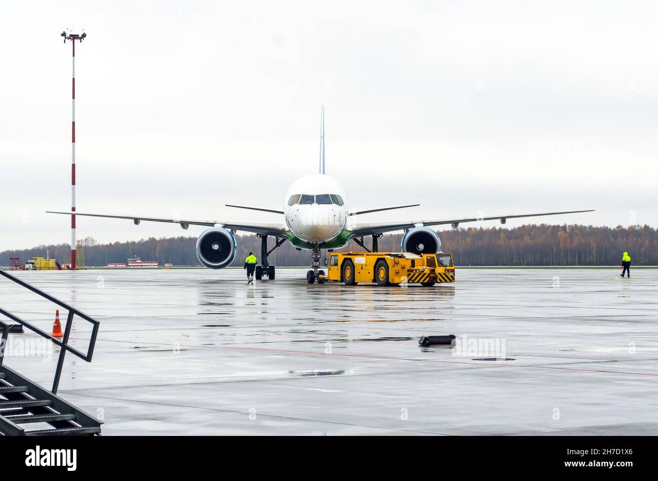 Chariot de remorquage repoussant l'avion jusqu'à la place de stationnement de l'aéroport Banque D'Images