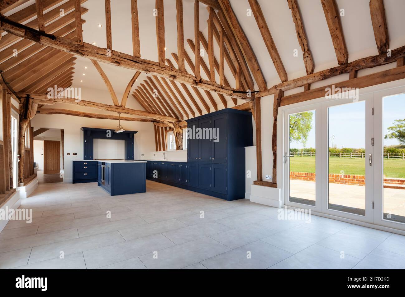 Great Sampford, Essex - avril 16 2020: Cuisine de luxe dans une grande grange britannique rénovée dominée par un plafond voûté avec de nombreuses poutres apparentes Banque D'Images Great Sampford, Essex - avril 16 2020: Cuisine de luxe dans une grande grange britannique rénovée dominée par un plafond voûté avec de nombreuses poutres apparentes Banque D'Images