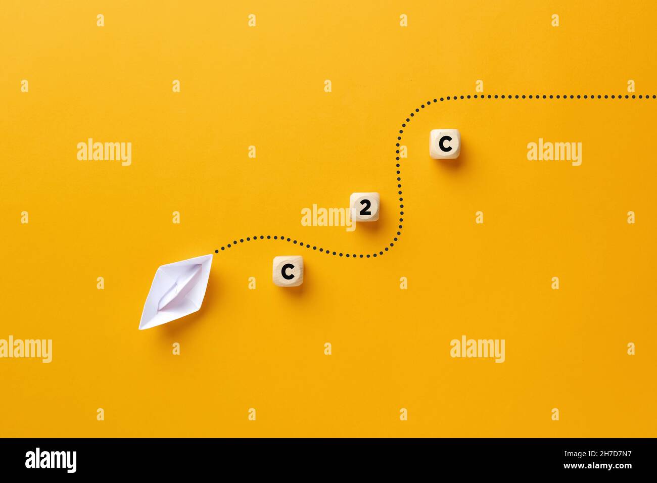 Le bateau à papier d'origami passe à travers les barrières de cube en bois avec l'acronyme C2C.Client à client, client à client ou client à client busine Banque D'Images