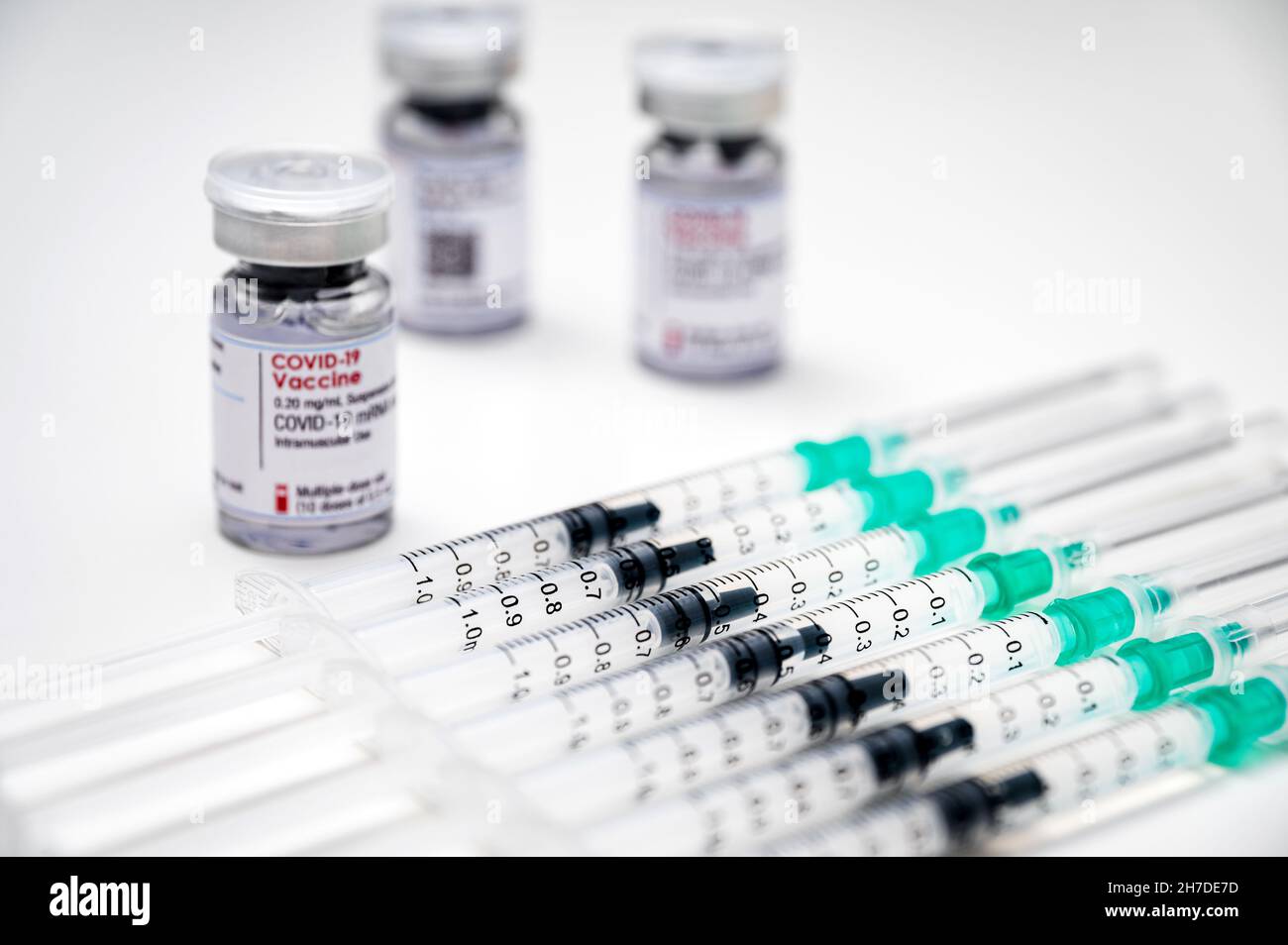 Vaccination contre le coronavirus du SRAS-COV-2 – seringues médicales, chacune avec une dose de vaccin COVID-19 et plusieurs flacons en verre à l'arrière-plan. Banque D'Images