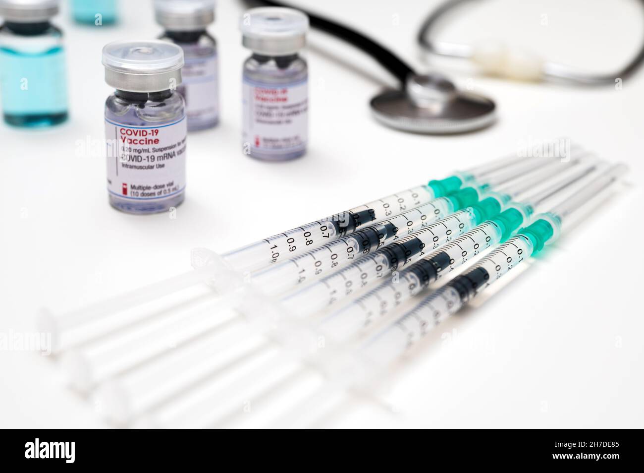 Vaccination contre le coronavirus du SRAS-COV-2, seringues médicales, chacune avec une dose de vaccin COVID-19; avec plusieurs flacons en verre et un stéthoscope médical Banque D'Images