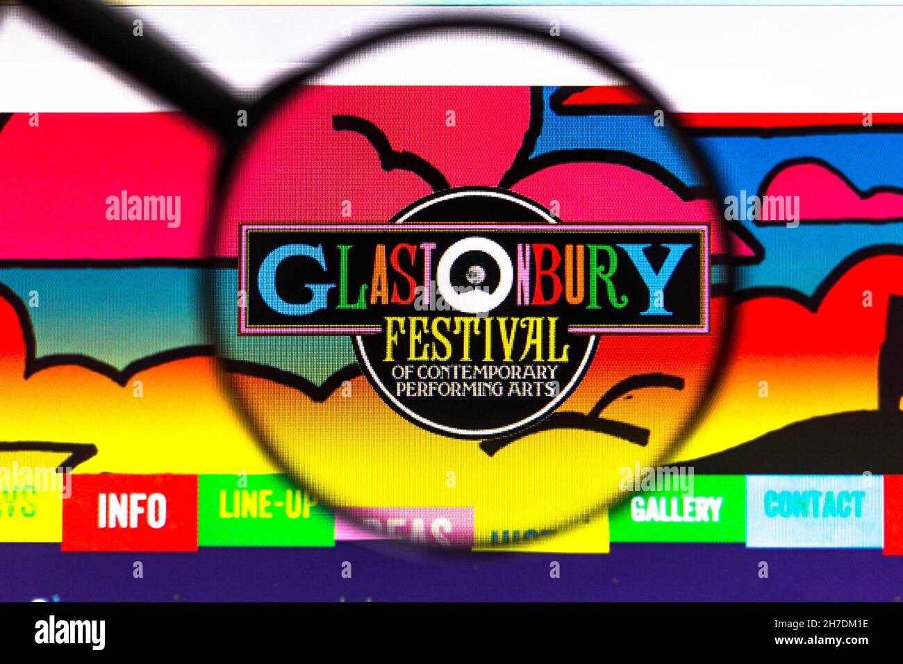 Dans cette illustration, un logo Glastonbury Festival of Contemporary Performing Arts (Glastonbury Festival of Contemporary Performing Arts, festival des arts de la scène contemporains) est affiché sur un écran d'ordinateur à travers une loupe. Banque D'Images