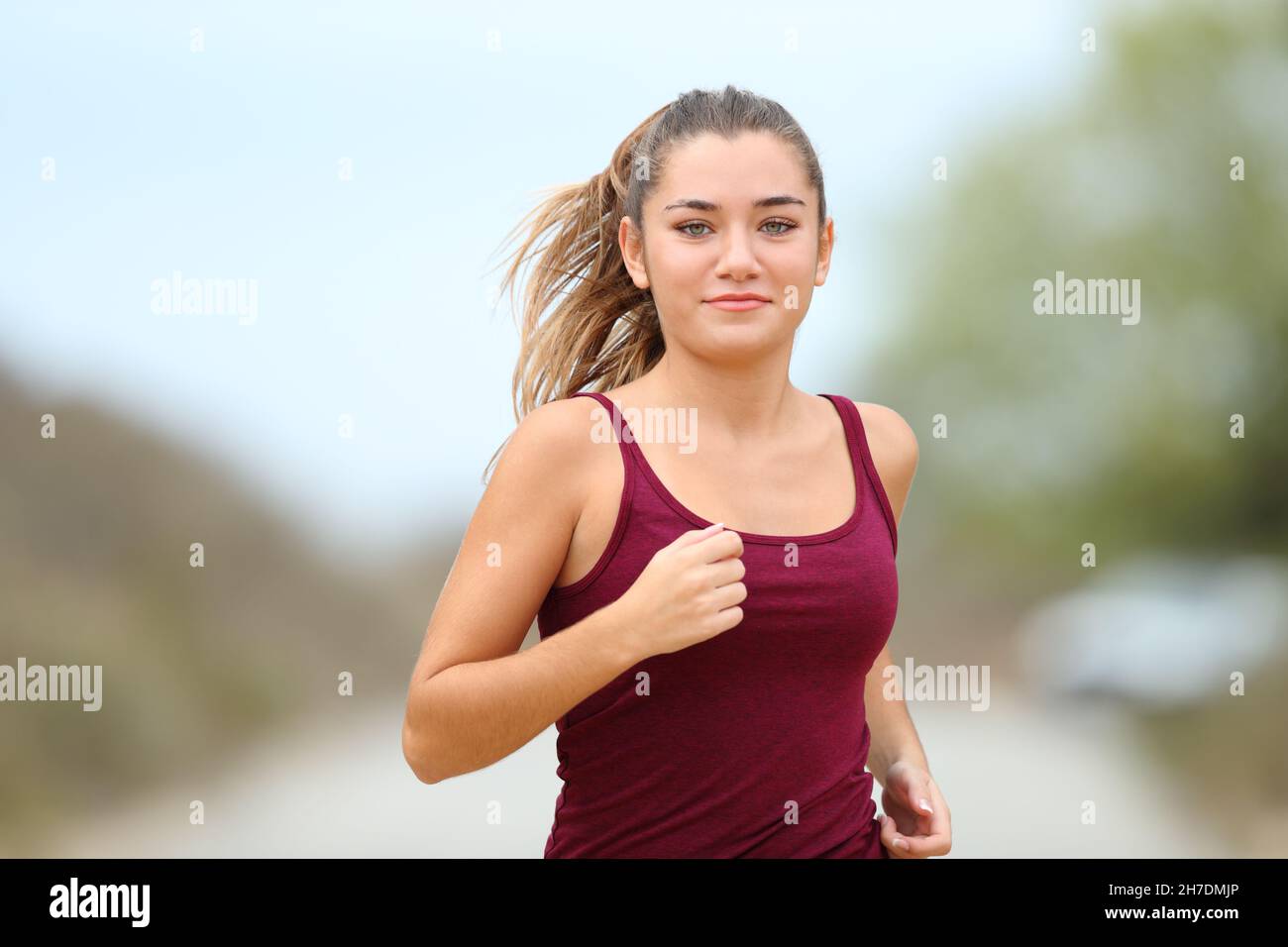 Vue de face d'un coureur adolescent courant dans la montagne Banque D'Images