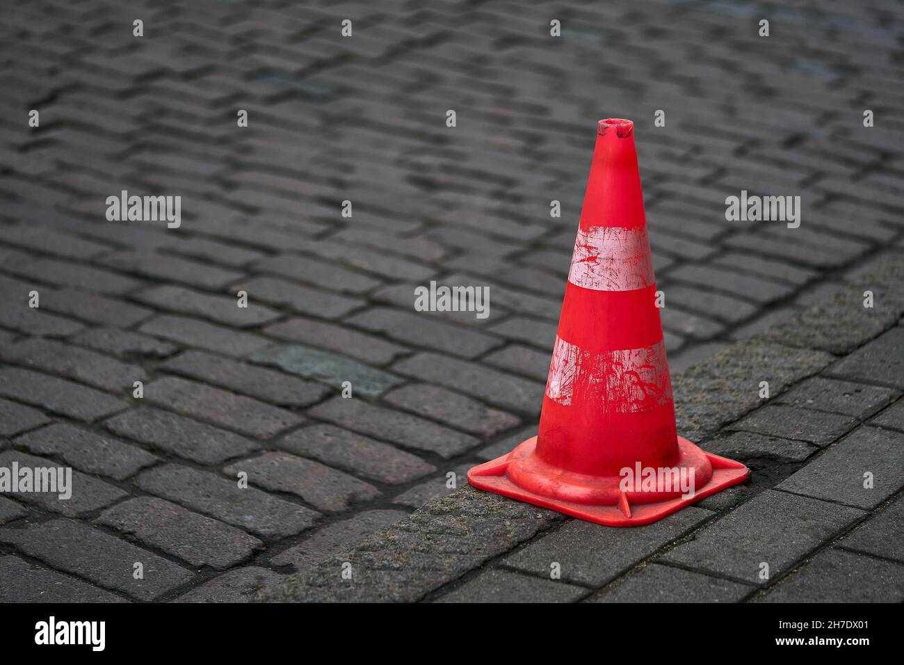 Cônes de signalisation orange vif debout dans une rangée sur l'asphalte sombre Banque D'Images