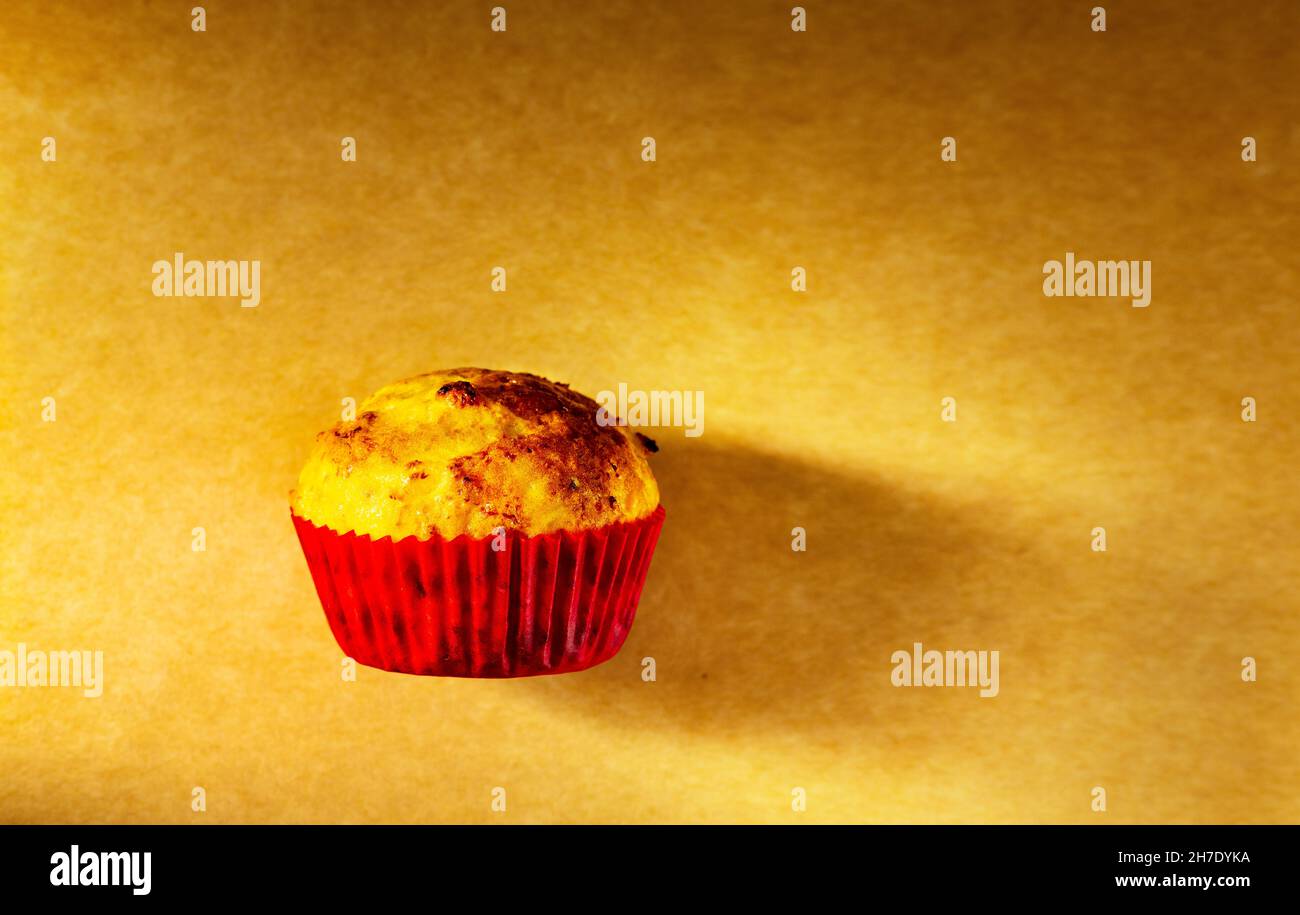 un cupcake est photographié avec une petite lumière dans le studio sur un fond de papier ancien.Cuisine maison Banque D'Images