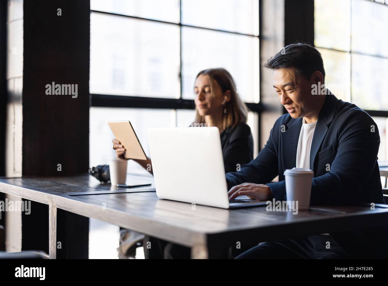 Homme montrer quelque chose sur ordinateur portable à la femme dans le café Banque D'Images