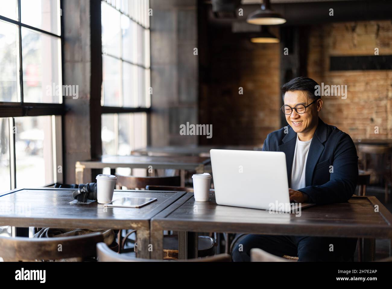 Homme d'affaires tapant sur un ordinateur portable pendant son travail dans un café Banque D'Images
