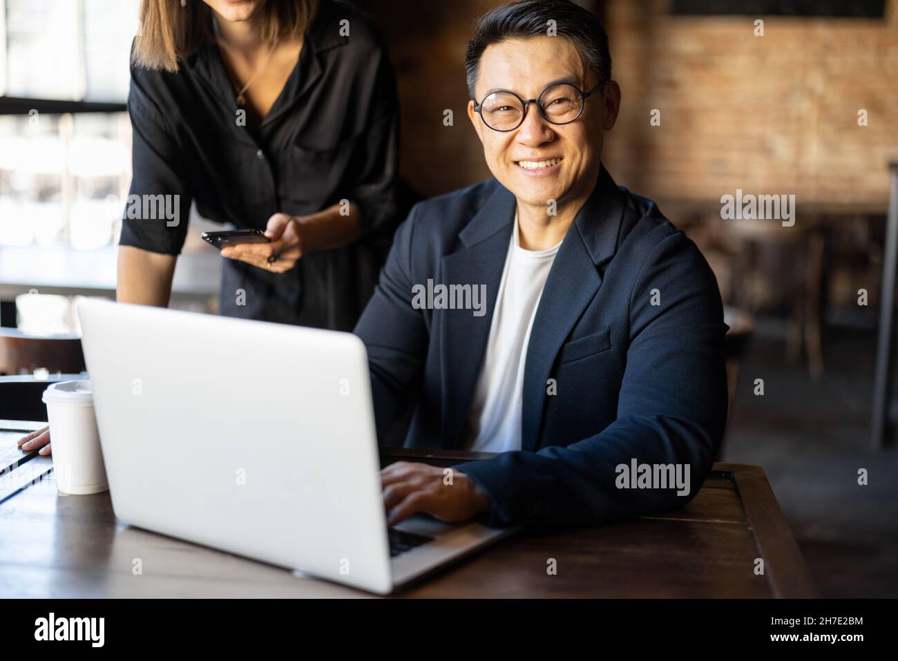 Homme montrer quelque chose sur ordinateur portable à la femme dans le café Banque D'Images