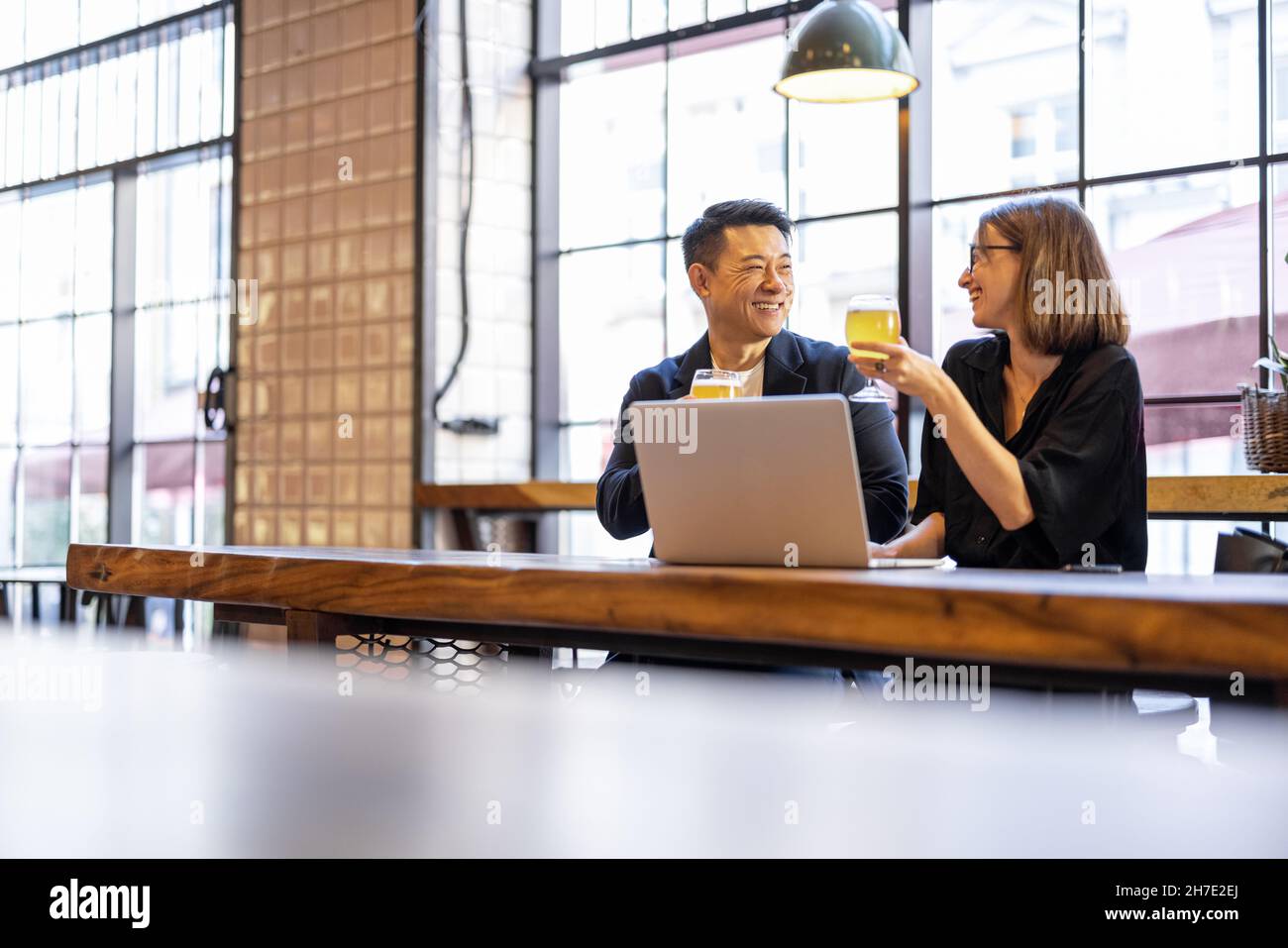 Des amis parlent et boivent de la bière au bar Banque D'Images