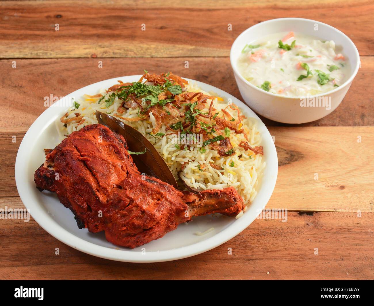 Poulet Tandoori et poulet Biryani servis sur fond de bois rustique.Plats et hors-d'œuvre de cuisine indienne, sélection Banque D'Images