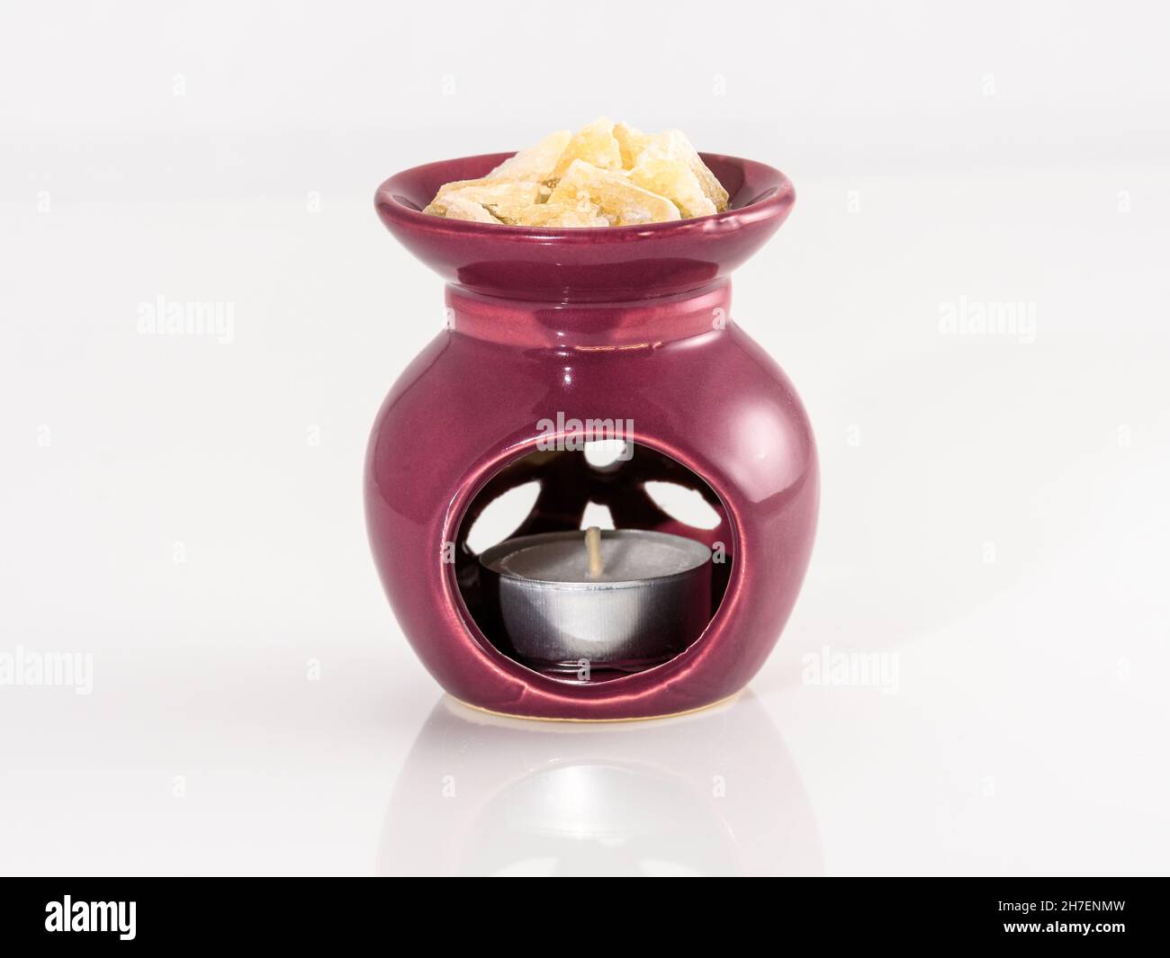 Lampe aromatique avec minéraux de Calcite et bougie en feu.L'huile aromatique est égouttée sur la calcite.Céramiques faites à la main Banque D'Images