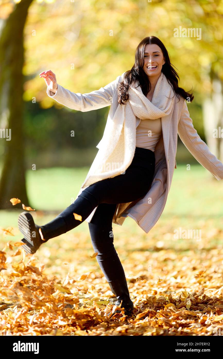 Fille brune coups de feuilles d'automne Banque D'Images