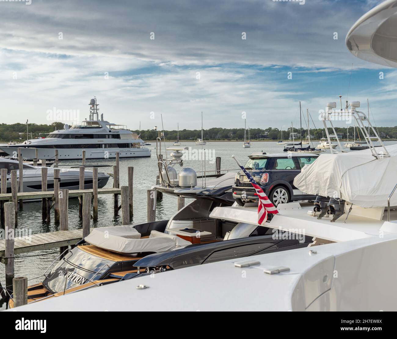 Un grand yacht à moteur avec une BMW mini et un tendre sur le pont Banque D'Images