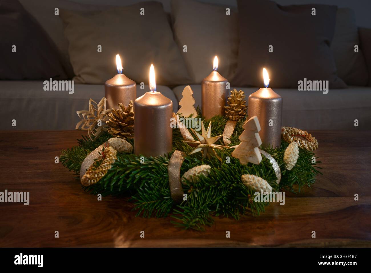 Couronne de l'Avent avec quatre bougies dorées et décoration d'hiver naturelle sur une table basse en bois le quatrième dimanche avant Noël, espace copie, s Banque D'Images