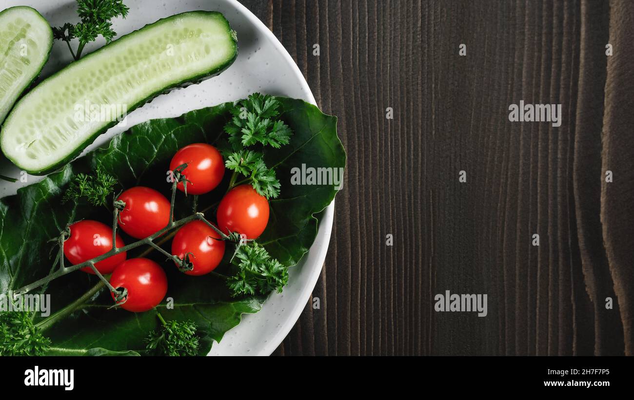 Légumes frais et herbes dans une assiette sur une table en bois.Concept de végétarisme et alimentation saine.CopySpace Banque D'Images