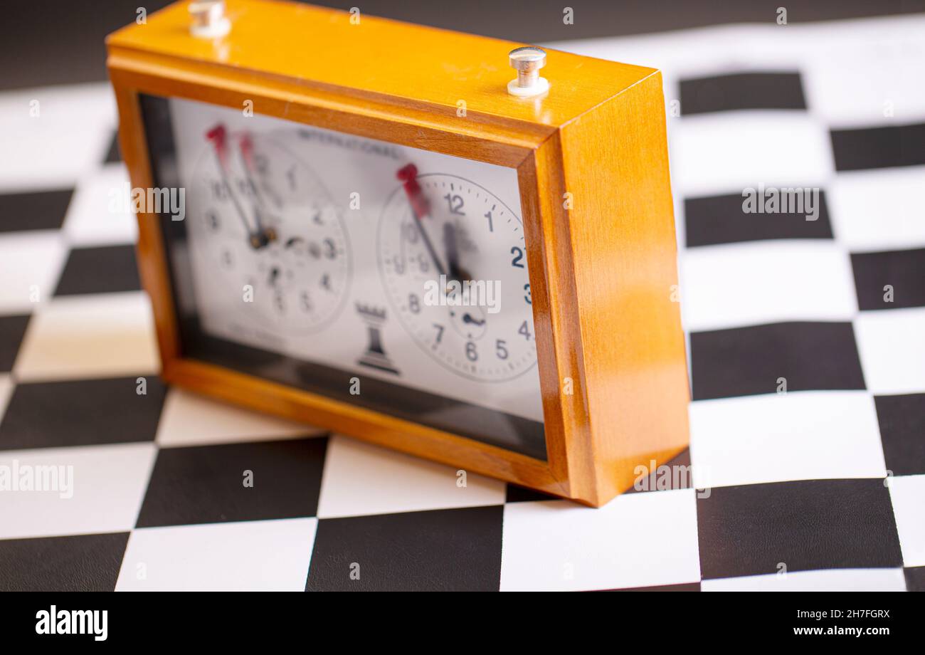 horloge d'échecs classique et mécanique sur un plateau d'échecs en bois Banque D'Images