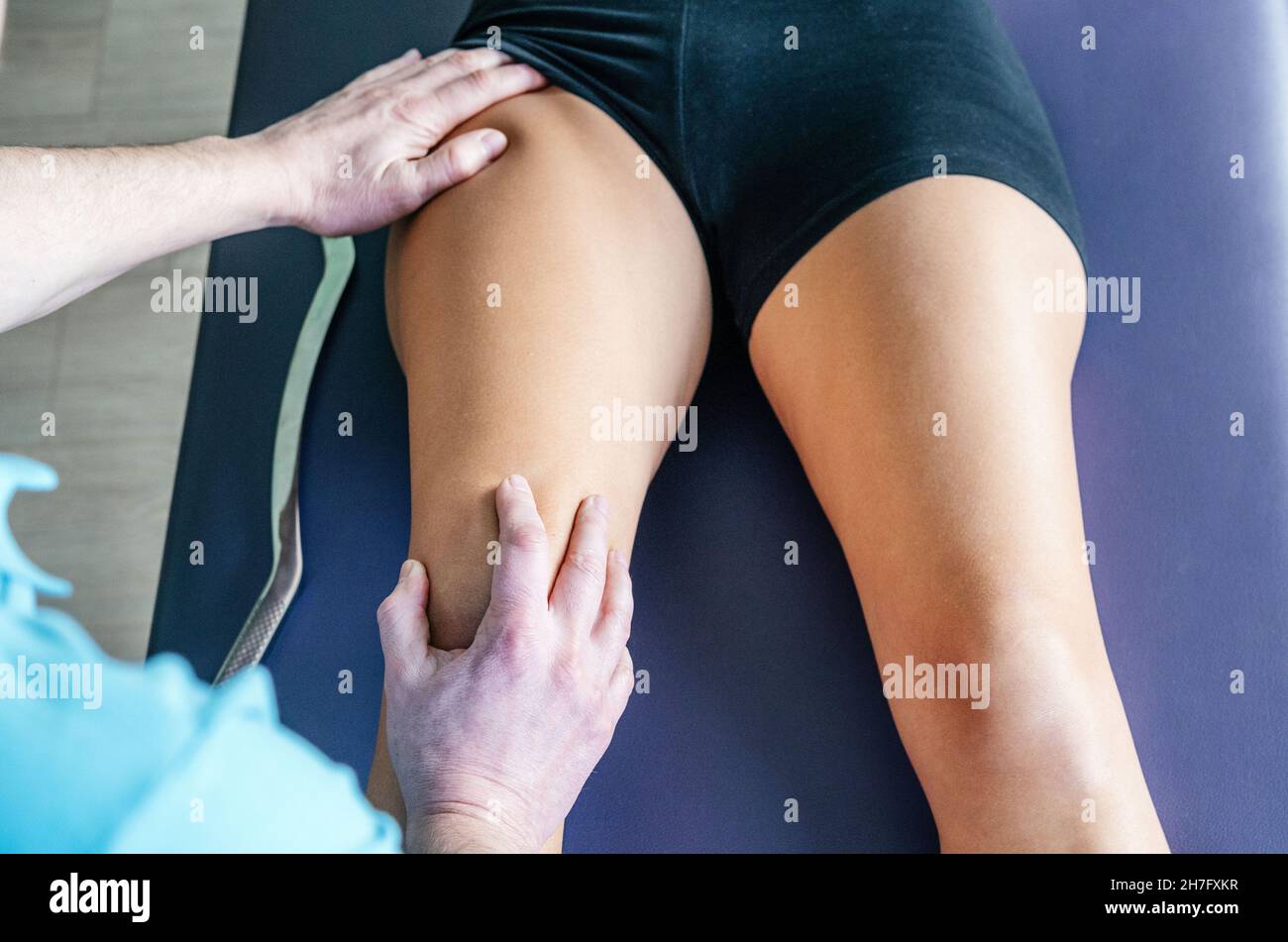 Ostéopathe réalisant la libération myofasciale pour le muscle du fémoris des quads Banque D'Images