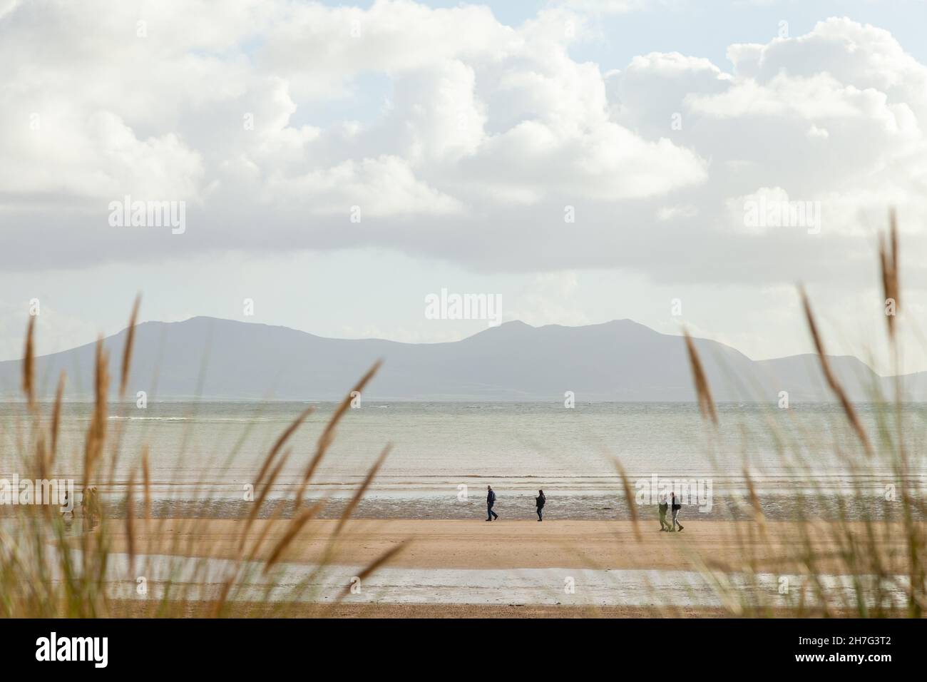 Personnes marchant sur la plage de Newborough, île d'Anglesey, pays de Galles Banque D'Images