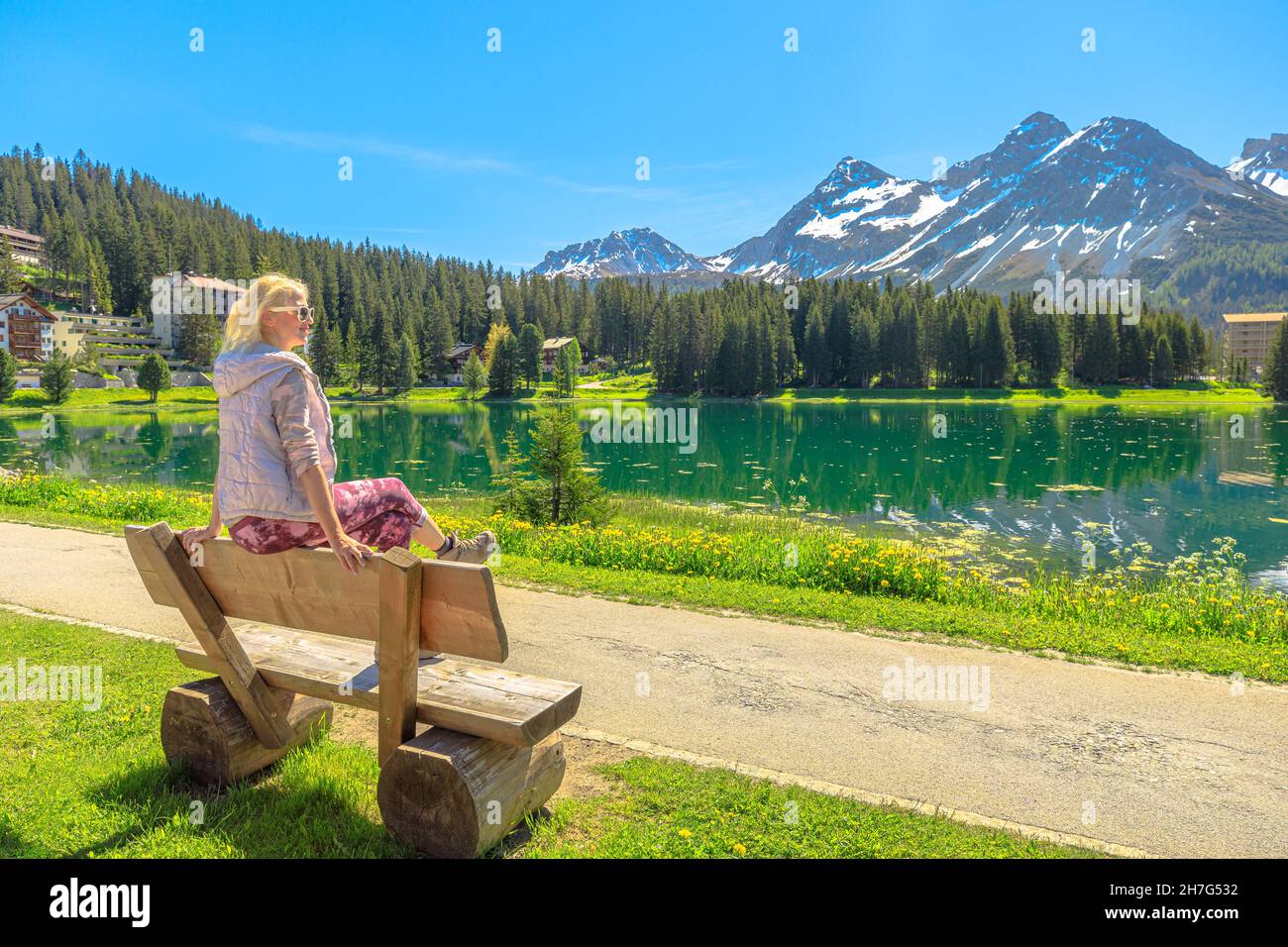 Femme suisse assise sur un banc de parc d'Arosa.Ville et station touristique près du lac Obersee en Suisse.Arosa en bord de lac par la station de téléphérique à Aroser Banque D'Images