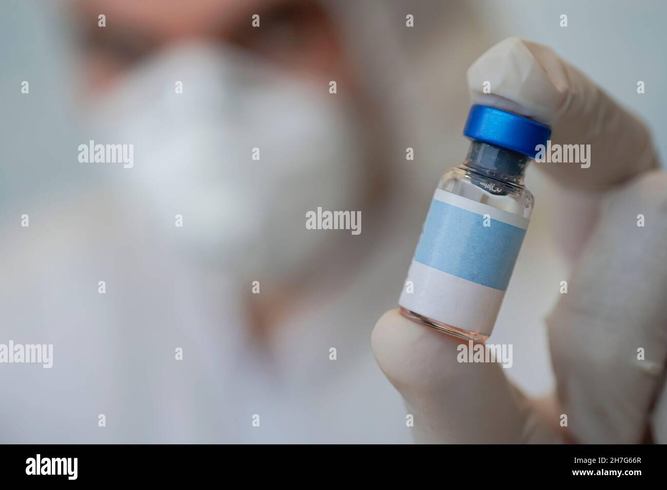 Concept médical de la santé. Le médecin tient dans sa main une bouteille de vaccin et une étiquette vierge pour le texte ou la conception publicitaire. Gros plan d'une bouteille médicale Banque D'Images