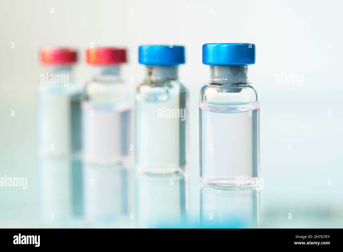 Médicament en flacons avec capsule rouge et bleue. Sur fond bleu. Copier l'espace. Banque D'Images