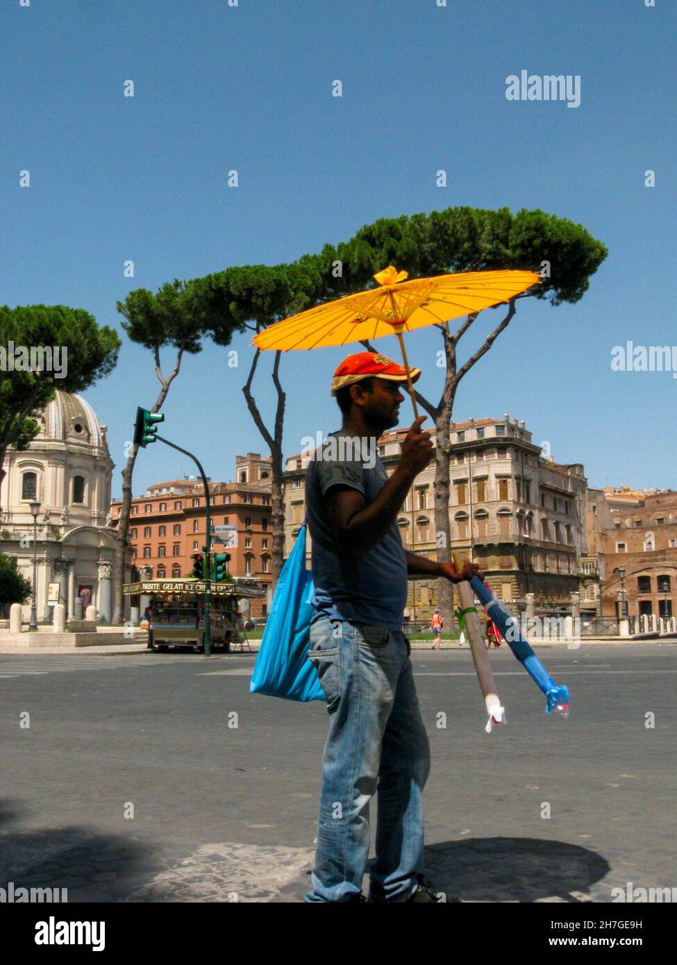 Vendeur de rue vendant des parapluies en papier coloré lors d'une chaude journée d'été à Rome en Italie à partir de 2013 Banque D'Images