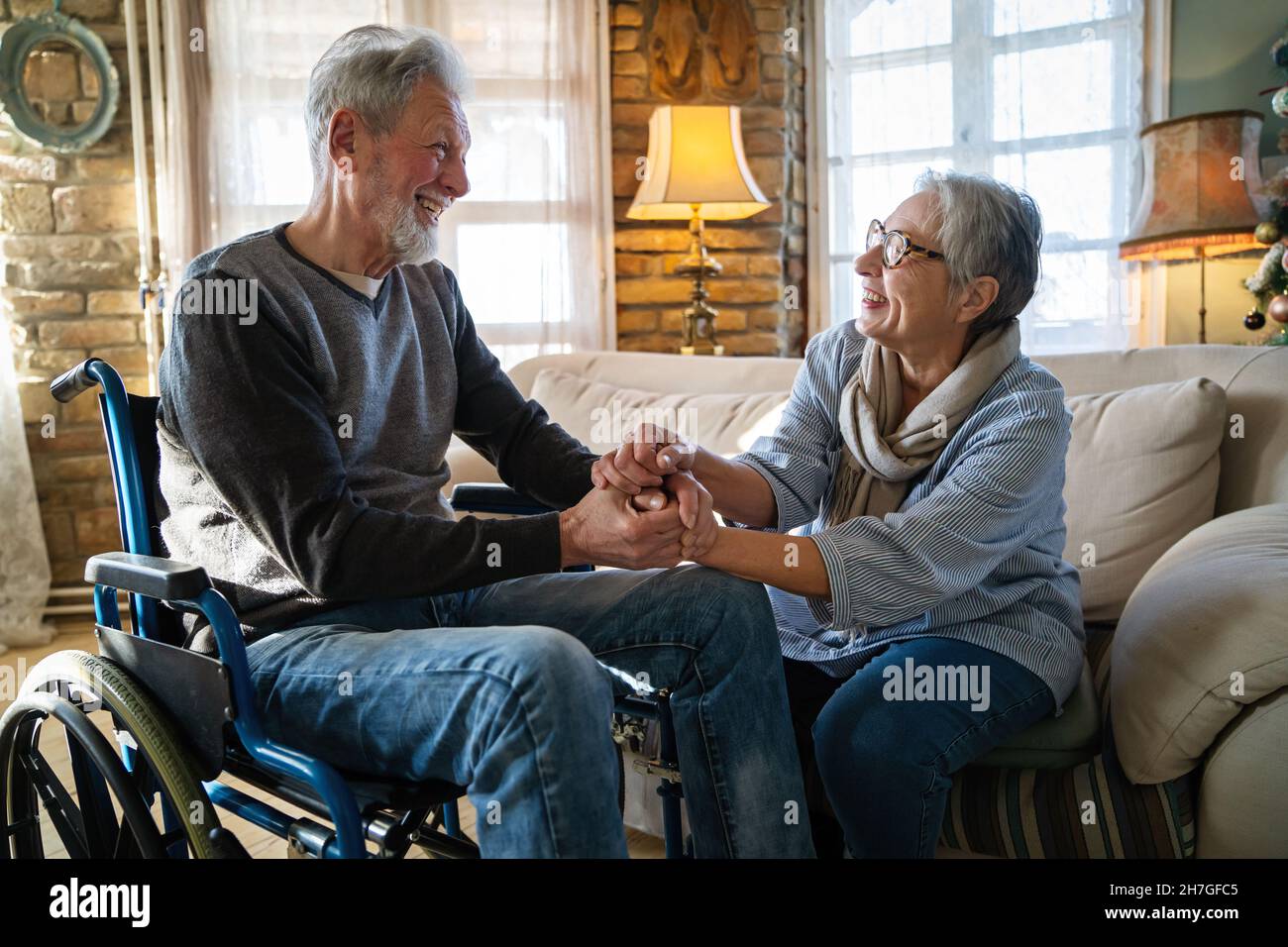 Homme mature ayant un handicap en fauteuil roulant passant du temps avec sa femme à la maison Banque D'Images