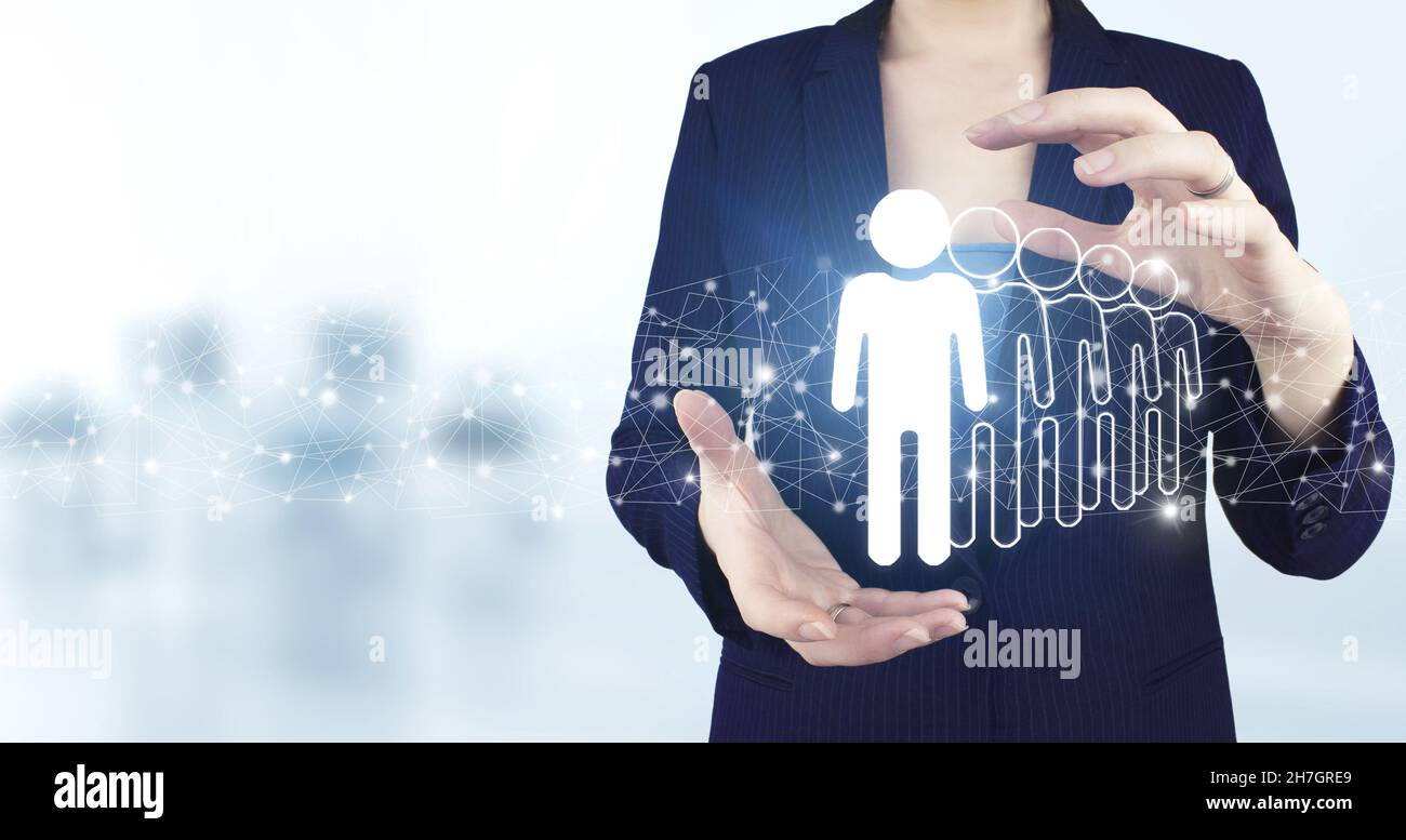 Concept de gestion des ressources humaines et de l'équipe.Deux mains tenant Virtual holographic Human, icône leader avec un arrière-plan flou clair.Recherche humaine.Leade Banque D'Images