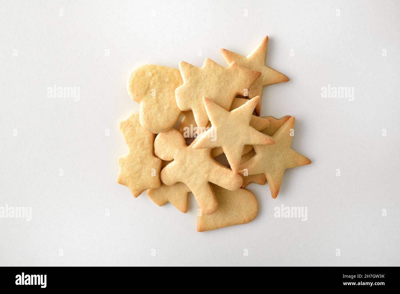 Assortiment de biscuits en forme de Noël dans un tas sur une table blanche.Vue de dessus.Composition horizontale. Banque D'Images