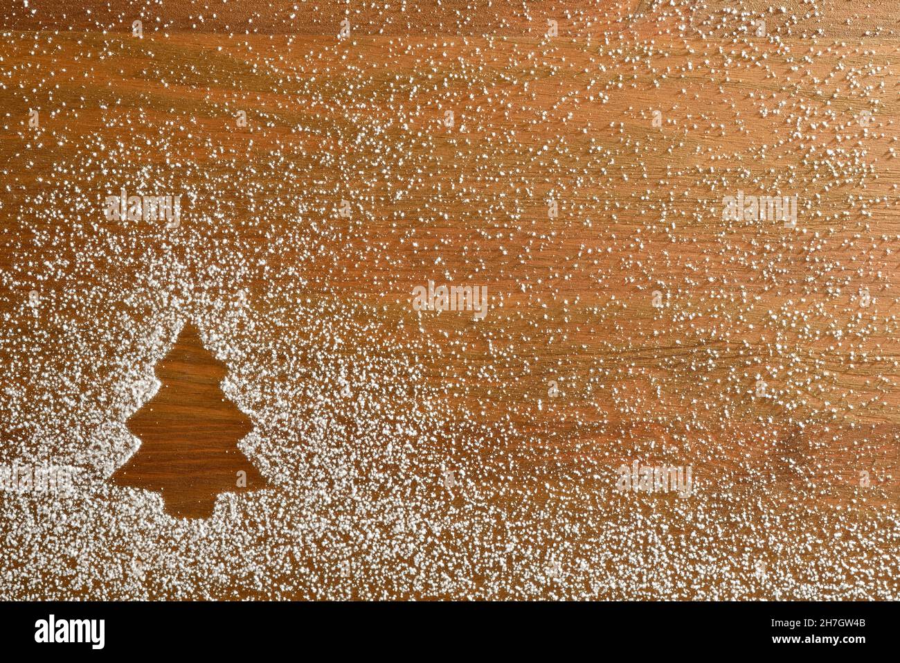 Fond de Noël en forme de sapin dessiné avec de la poudre de sucre glace sur base en bois.Vue de dessus.Composition horizontale. Banque D'Images