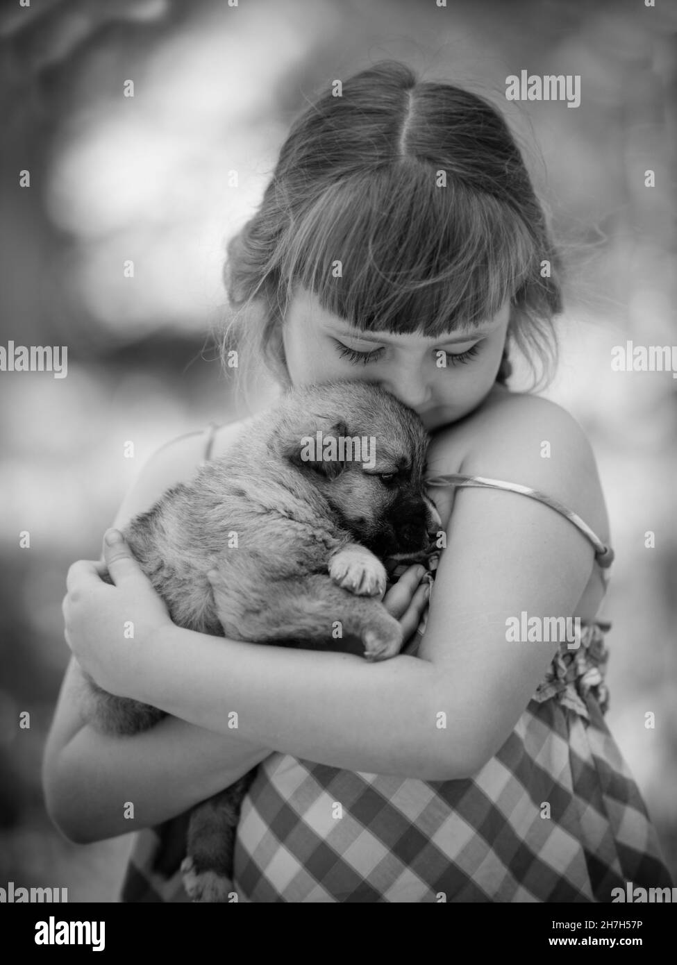 fille avec un chiot photo noir et blanc. Banque D'Images