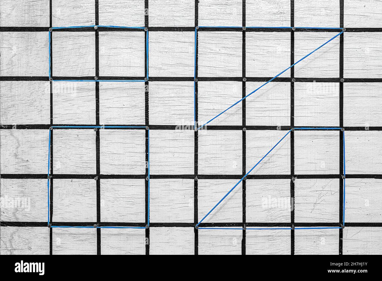 Géoplan blanc fait avec du bois et des clous, grilles noires peintes avec  des élastiques de bureau formant des figures géométriques Photo Stock -  Alamy