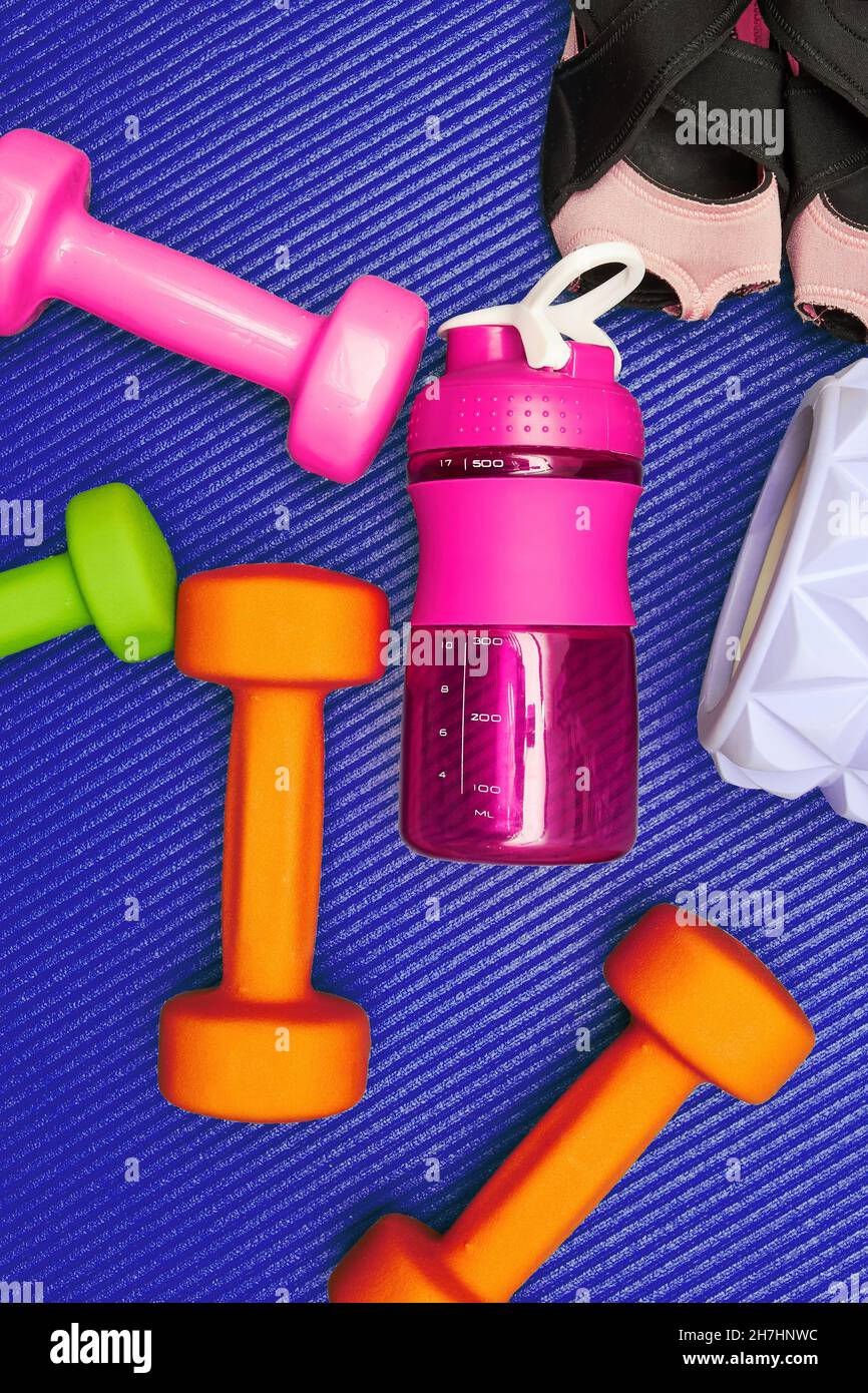 La vie fixe verticale avec l'équipement de fitness, haltères, rouleau, bouteille sur le tapis.Eqip de gym et de soins de santé Banque D'Images