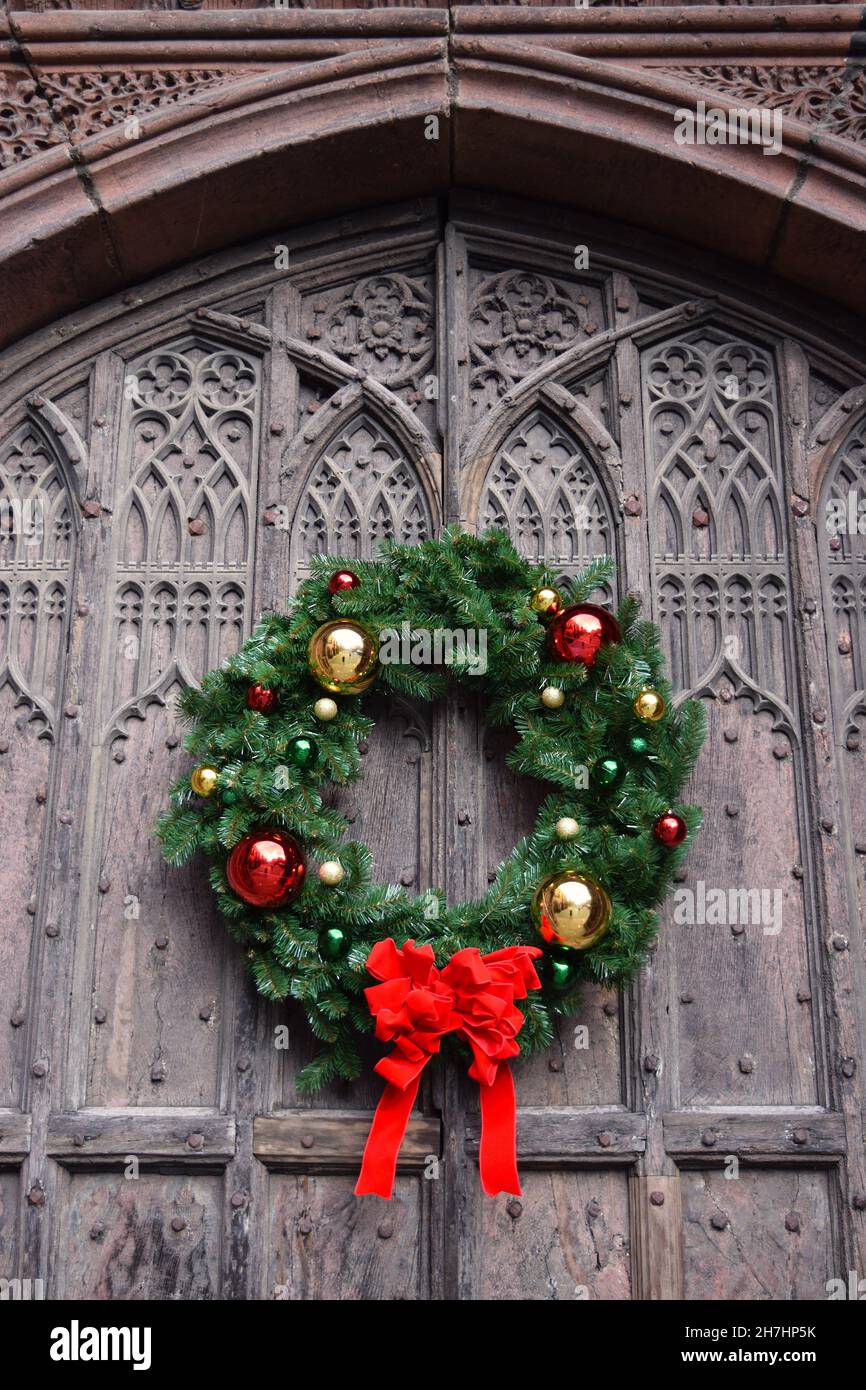 Couronne de Noël traditionnelle sur la porte en bois de la cathédrale de Chester. Banque D'Images