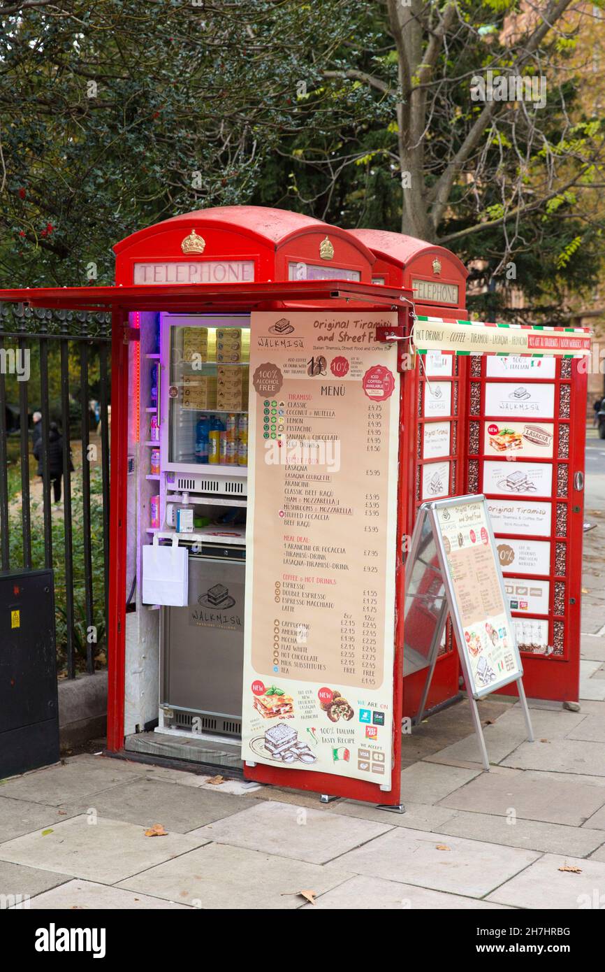 Les téléphones rouges traditionnels utilisés par un fournisseur sont visibles dans le centre de Londres. Banque D'Images