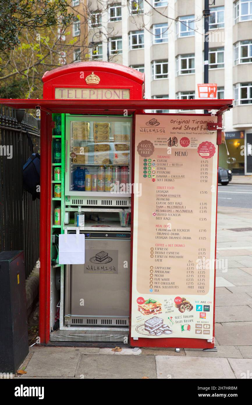 Les téléphones rouges traditionnels utilisés par un fournisseur sont visibles dans le centre de Londres. Banque D'Images