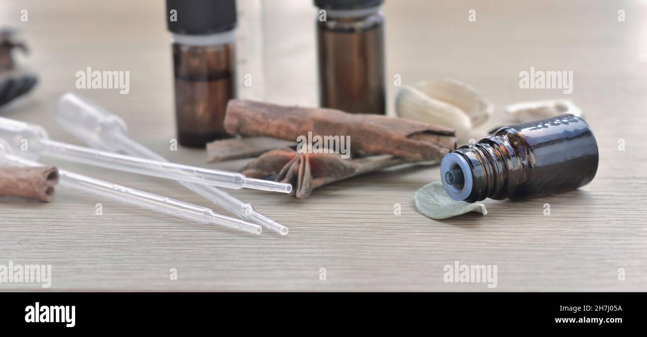 bouteilles d'huile essentielle et bâton de cannelle et d'anis sur une table en bois Banque D'Images
