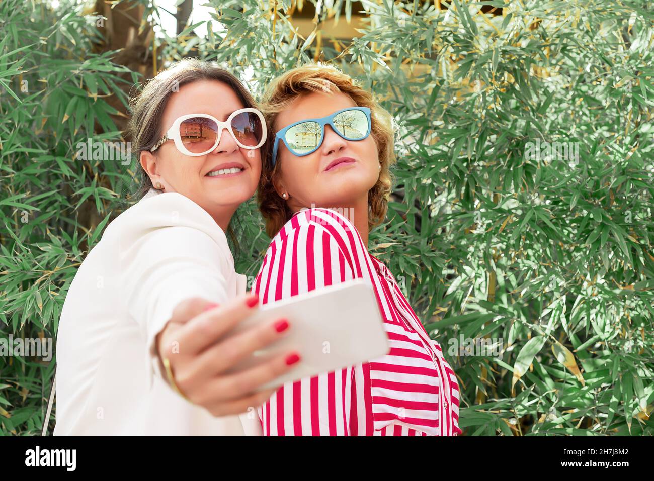 Deux femmes d'âge moyen du Caucase portant des lunettes de soleil prenant un selfie Banque D'Images