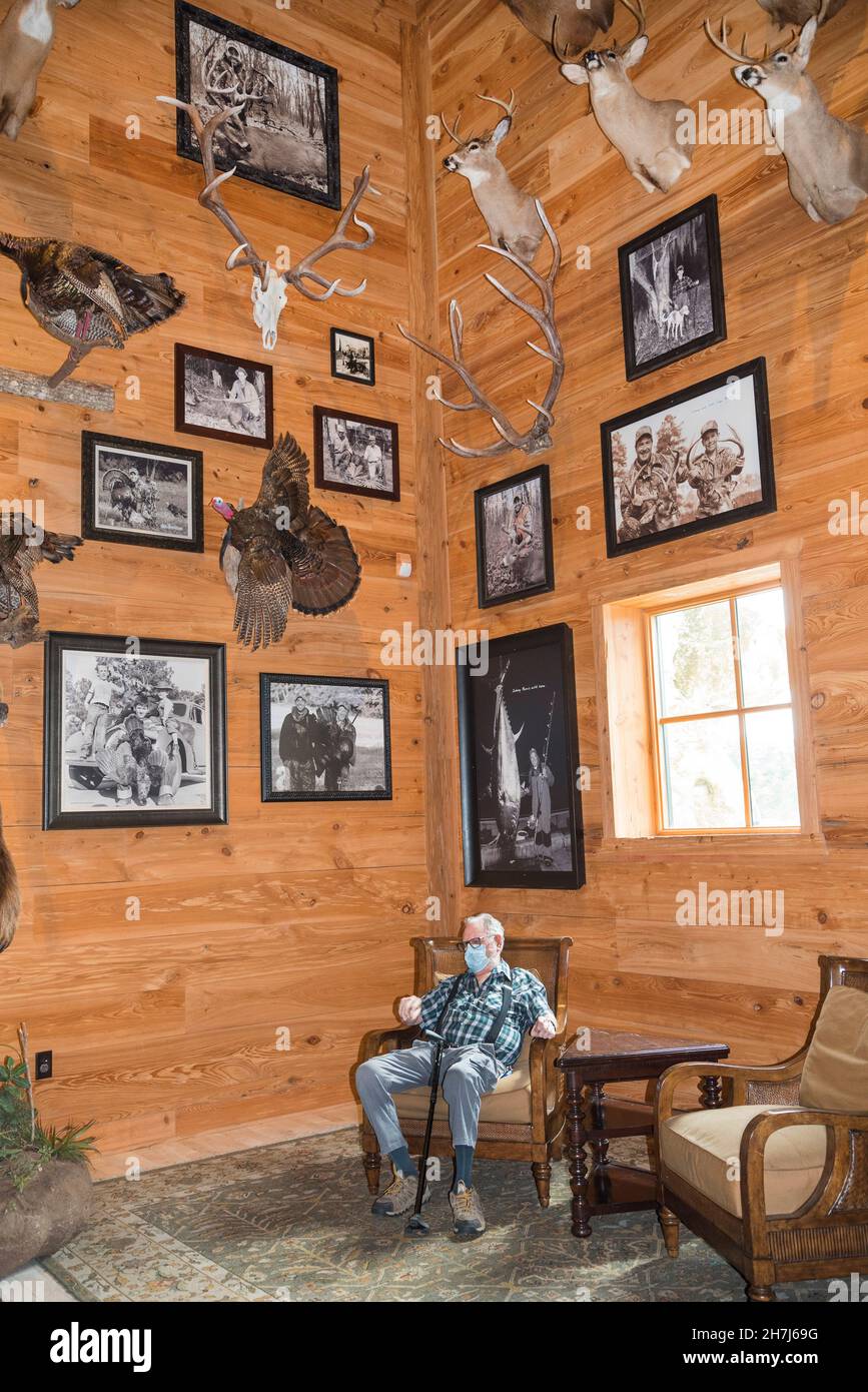 L'homme se détend tandis qu'il est entouré d'animaux en peluche à l'intérieur d'un magasin de loisirs en plein air dans le centre-nord de la Floride. Banque D'Images