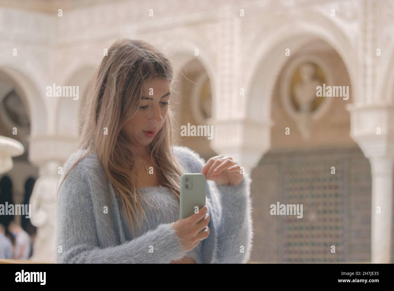 Fille touristique tenant un téléphone portable prenant une photo à la belle décoration marocaine dans le temple touristique.Voyage pendant le virus corona 2021-2022 Banque D'Images