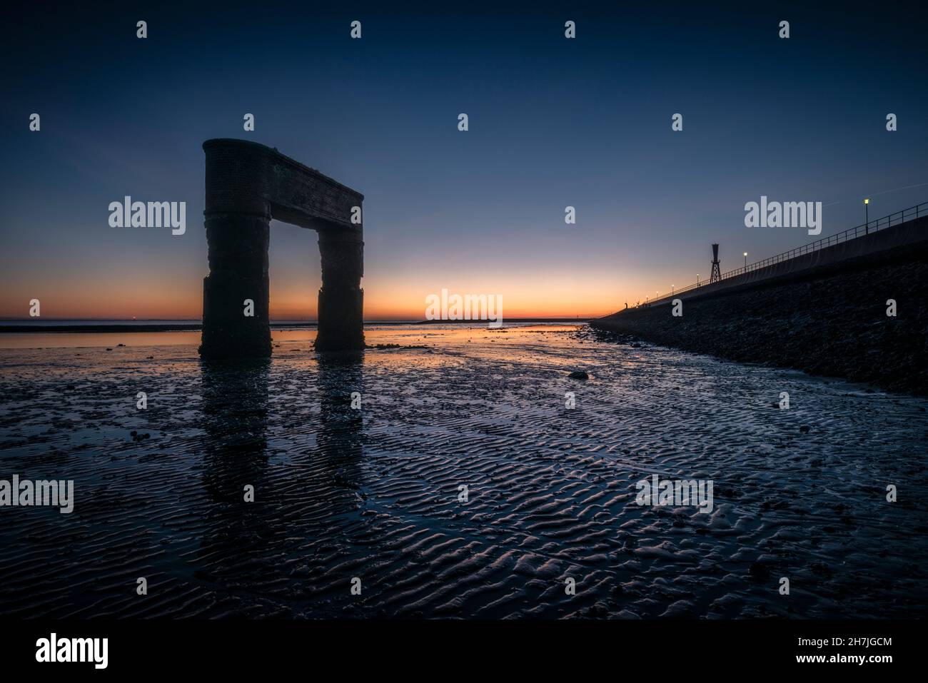 Ruine de l'ancien quai de ferry à Eckwarderhörne à marée basse dans la lumière du soir, Butjadingen, Wesermarsch, Basse-Saxe, Allemagne,Europe Banque D'Images