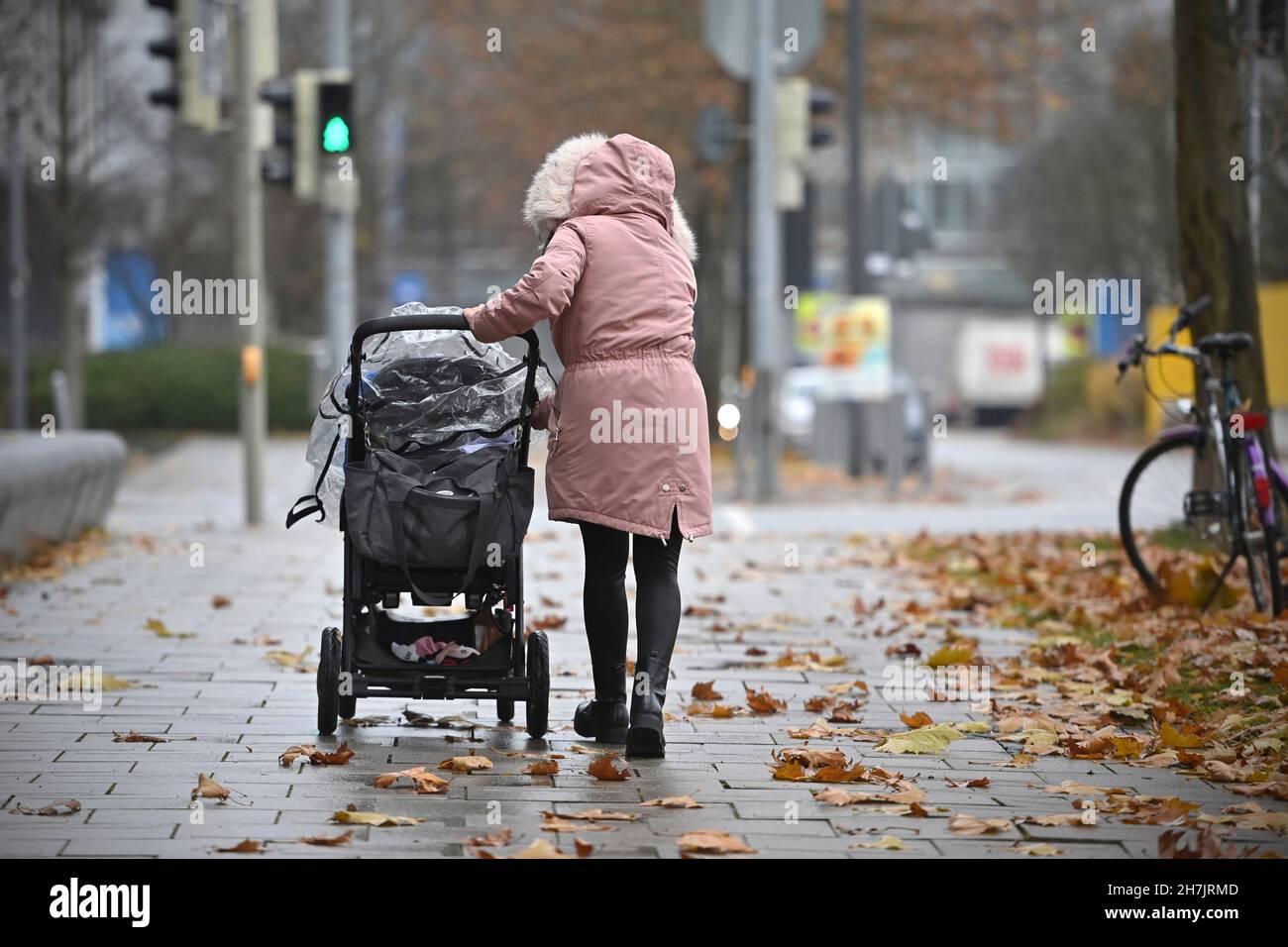 Munich, Allemagne.23 novembre 2021.Femme pousse un pram à Munich sur un gris novembre jour crédit: dpa/Alay Live News Banque D'Images