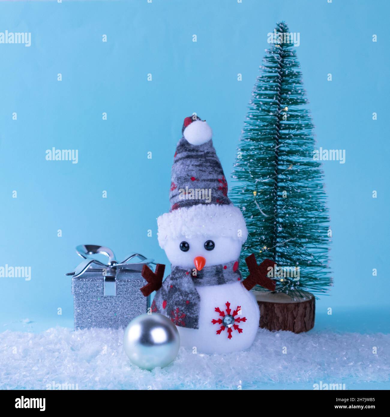 Bonhomme de neige, cadeau, arbre vert, blanc, boule de Noël sur neige  blanche sur fond bleu.Gros plan Photo Stock - Alamy